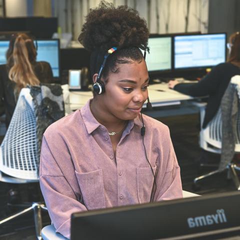 Contact met National Academic Jonge vrouw met telefonische headset achter computer
